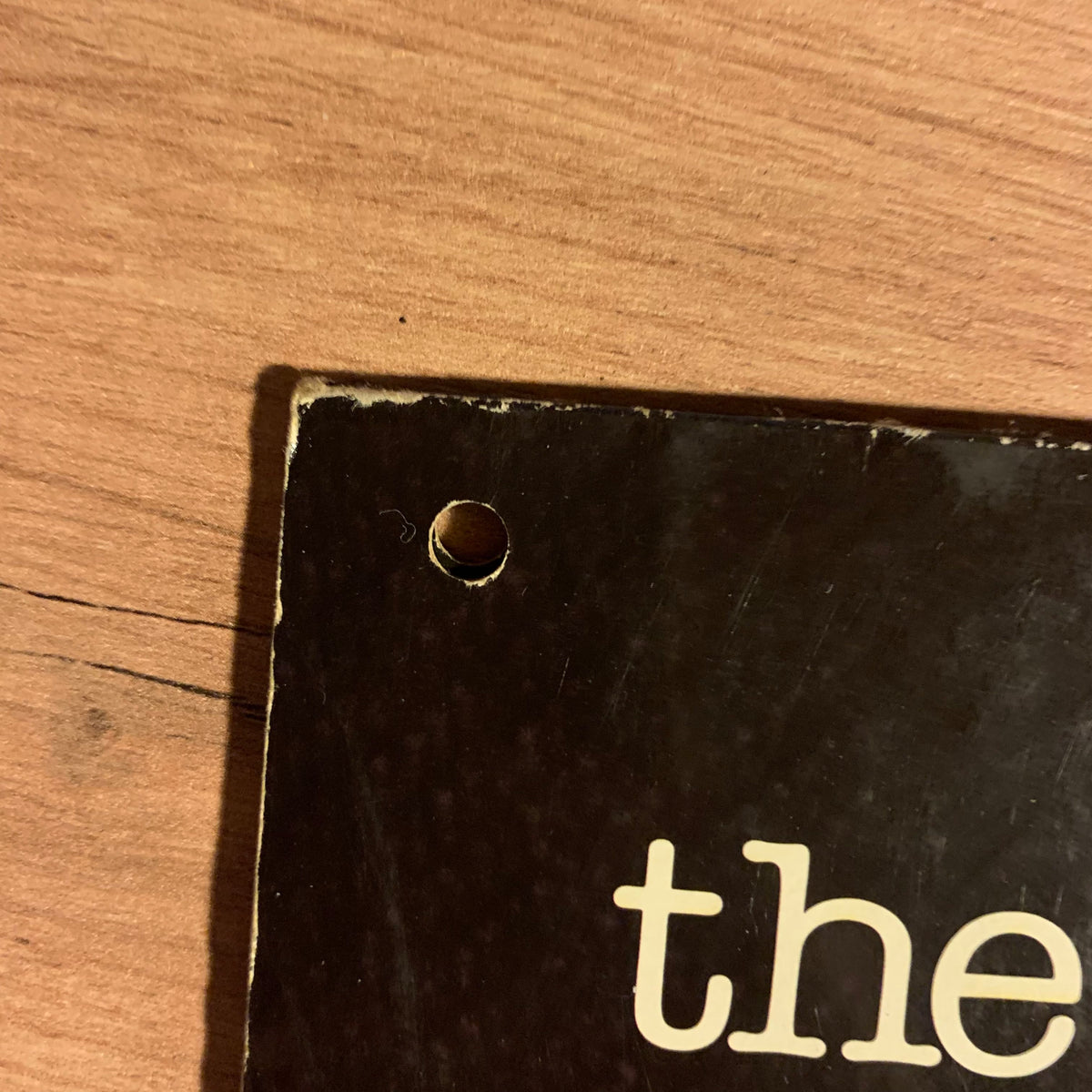Détail de la perforation et de l’usure du coin de la pochette